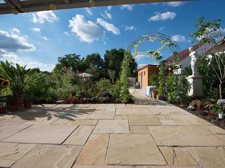 Přírodní zahrada se světlým pískovcem Yellow Mint a jasně modrou oblohou