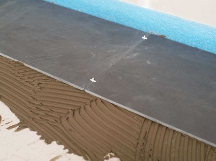 Spárovací kříže jako distanční prvky mezi dvěma břidlicovými dlaždicemi