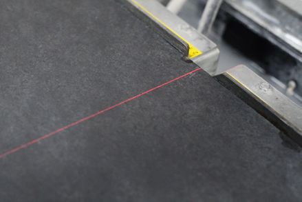 Infračervený laser ukazuje přesnou délku hrany během řezání.