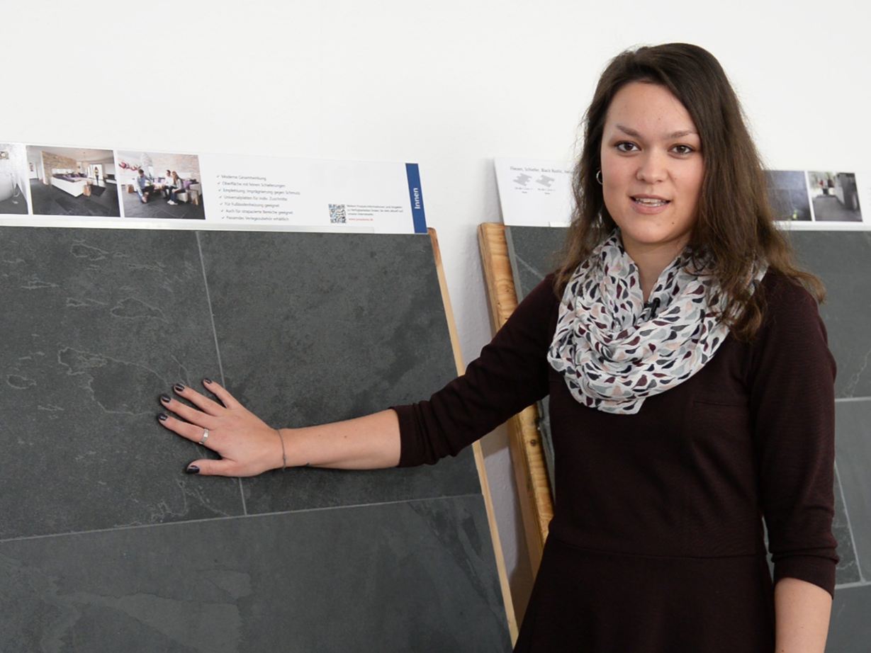 Zaměstnanec stojí před vzorovými břidlicovými deskami