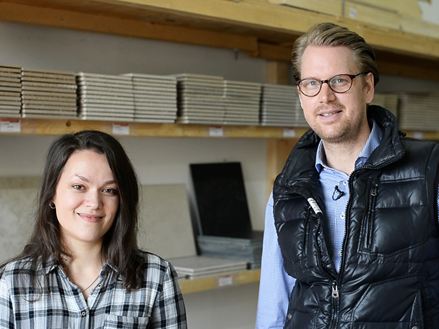 Zaměstnanec před regálem se vzorky dlaždic