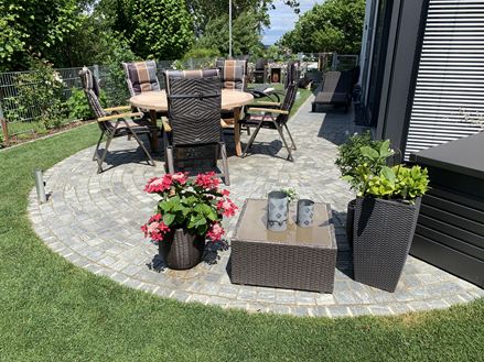 Dlažební kostky Gneiss Urban Grey Line v zelené barvě s květinami