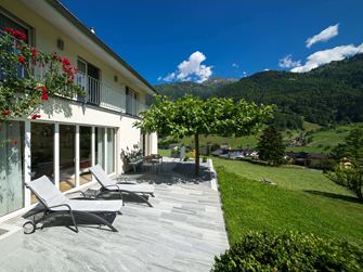 Terasa s žulovými deskami, lehátky a horami v pozadí