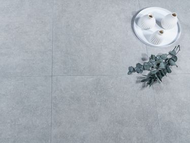 Kamenné dlaždice vzhledu čediče s vázami a eukalyptem