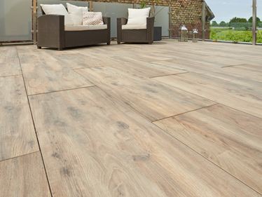 Terasa s moderním ratanovým nábytkem a obložením s dřevěným efektem Terasa Canada Lodge z žabí perspektivy