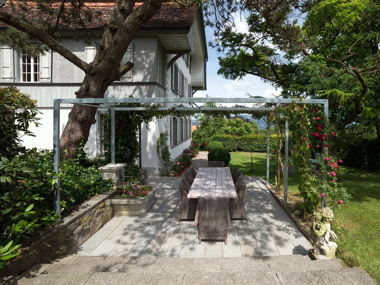 Terasa s přírodními kamennými deskami z šedého pískovce v přírodní zahradě