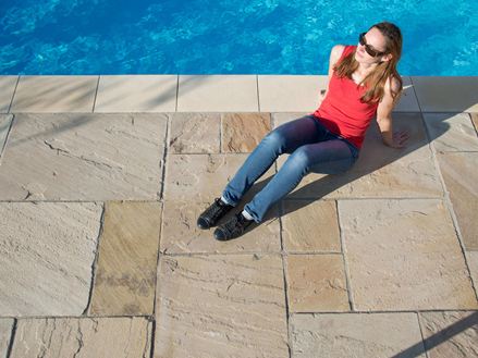 Večerní slunce na pískovcových deskách Yellow Mint se ženou u bazénu