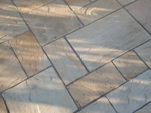 Světlé pískovcové desky v římské vazbě fotografované shora.