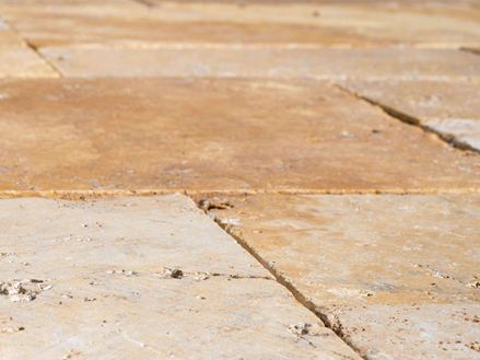 Detail travertinových desek Gold ve venkovním prostoru z pohledu žáby