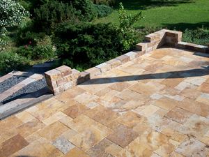 Gold travertinová deska položená v římské vazbě se zdí z přírodního kamene a přilehlou zahradou