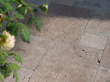 Pozdně odpolední slunce hraje na podlaze terasy, zprava vyčnívají do obrazu větve.