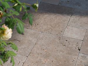 Pozdně odpolední slunce hraje na podlaze terasy, zprava vyčnívají do obrazu větve.