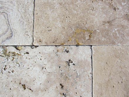 Detailní záběr na tromlované travertinové desky s charakteristickými vrypy