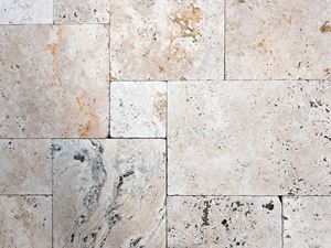 Travertinové desky shora v římské vazbě s živou hrou barev v odstínech béžové a hnědé.