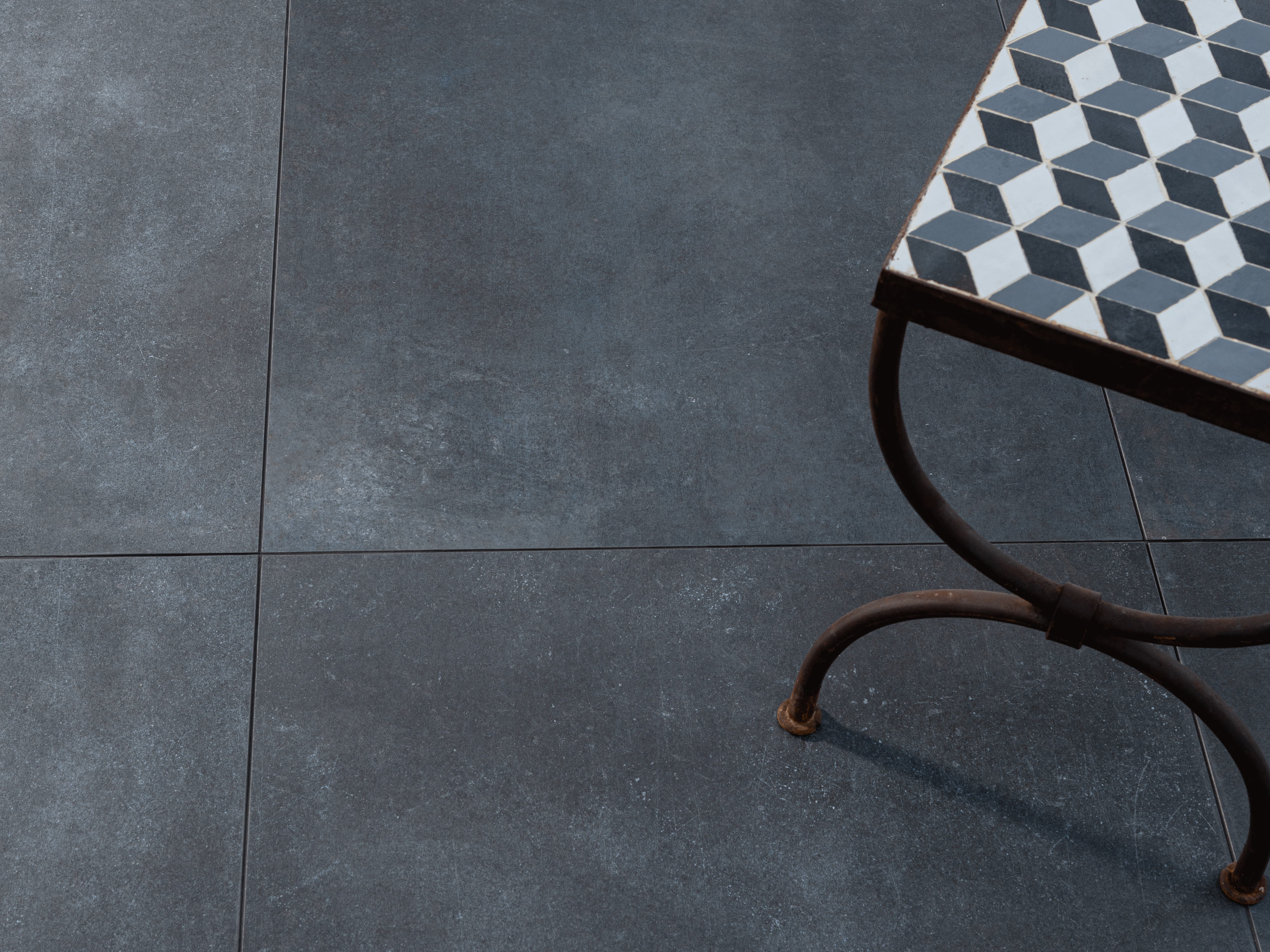 Dlaždice: módní městský styl Tmavé betonové dlaždice s postranním stolkom vyfocené shora