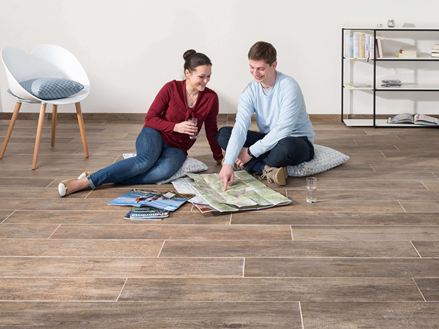 Pár sedí na jemné kamenné podlaze Indie Nova a dívá se na mapu