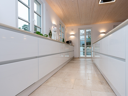 Otevřená kuchyně s vápencovými obklady Cleopatra Light a bílým kuchyňským nábytkem