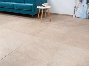 Dlaždice ve vzhledu vápence s tyrkysovou pohovkou a bílým stolkem