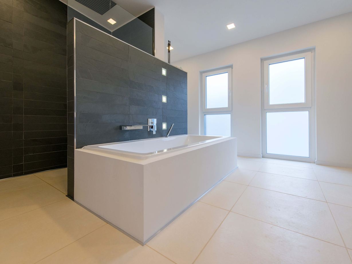 Vana na světlých vápencových dlaždicích a břidlice jako obklad stěn