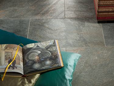 Kniha a polštář na položené křemencové dlaždici Deoli Green