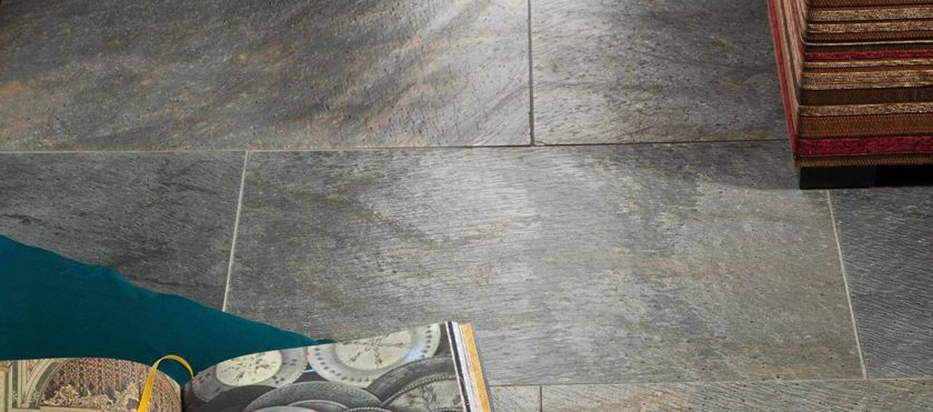 Kniha a polštář na položené křemencové dlaždici Deoli Green