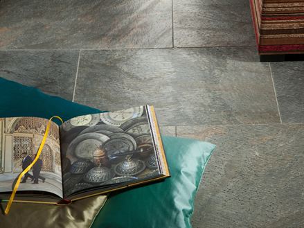 Kniha a polštář na položené křemencové dlaždici Deoli Green