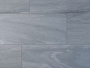 Kamenné dlaždice v šedé a bílé barvě na fotografii shora