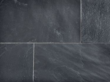 Detailní záběr na položené břidlicové dlaždice se světlými spárami