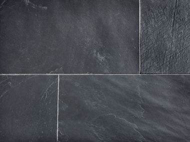 Detailní záběr na položené břidlicové dlaždice se světlými spárami