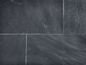 Detailní záběr na položené břidlicové dlaždice se světlými spárami