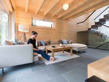 Žena v obývacím pokoji s dlažbou Grey Slate a dřevěnou stěnou