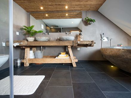 Rustikální koupelna s břidlicovými obklady a dřevěným nábytkem