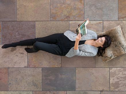 Žena ležící na barevných břidlicových dlaždicích Peacock Multi Color a čtení