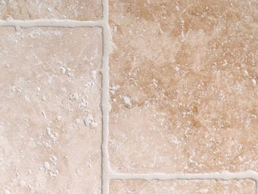 Světlé travertinové dlaždice s tromlovanými hranami