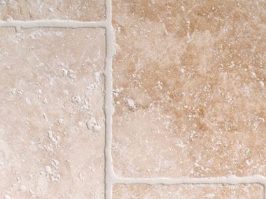 Světlé travertinové dlaždice s tromlovanými hranami