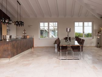 Travertinové obklady v římské vazbě v moderní kuchyni s jídelním stolem a kuchyňským ostrůvkem