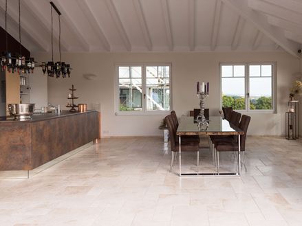 Travertinové obklady v římské vazbě v moderní kuchyni s jídelním stolem a kuchyňským ostrůvkem