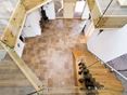 Vstupní prostor s travertinovou dlažbou Noce SELECT a dřevěným schodištěm shora