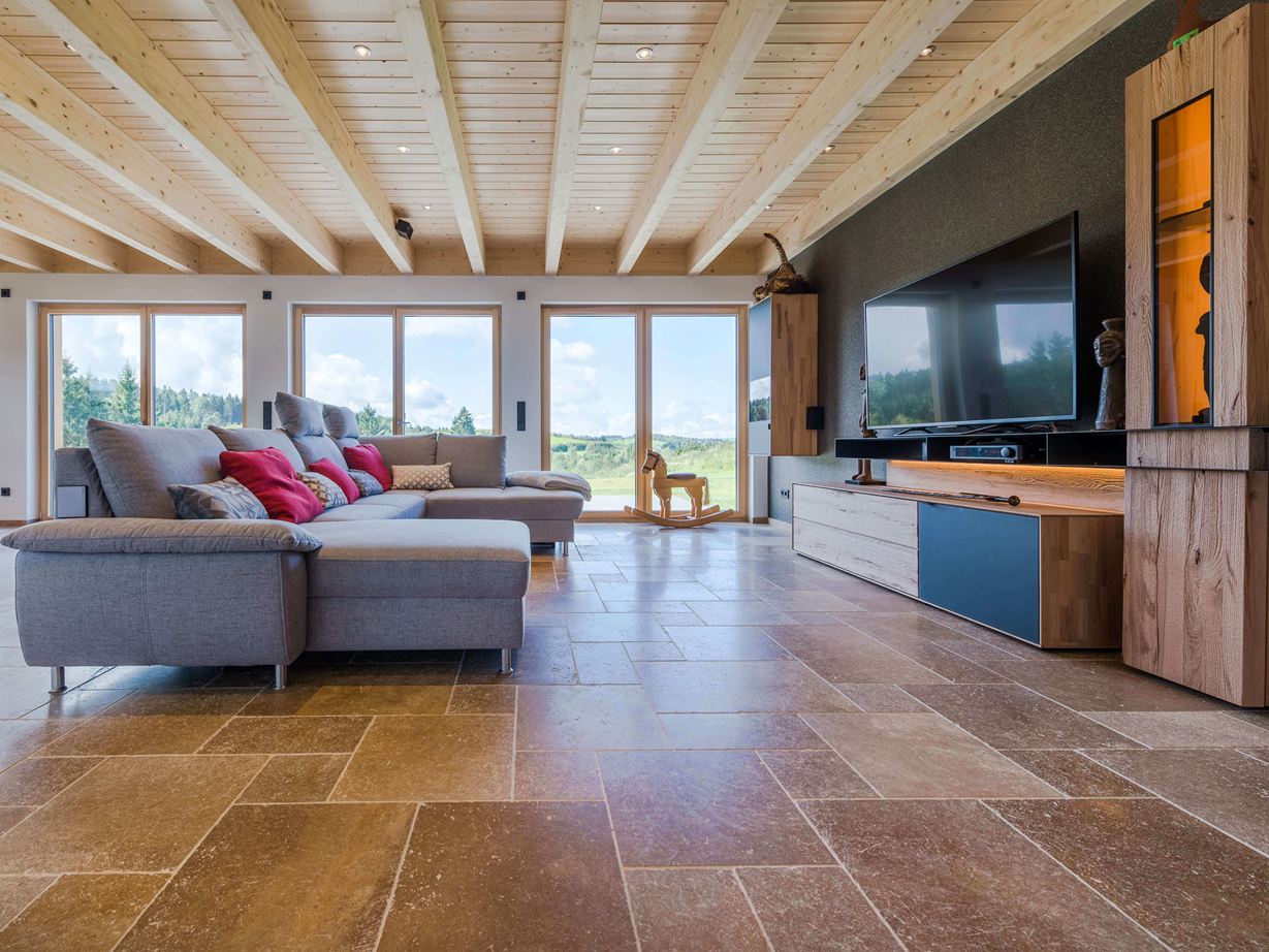 Útulný styl s ořechově hnědým travertinem Obývací pokoj s šedou pohovkou a ořechově hnědou travertinovou dlažbou Noce SELECT