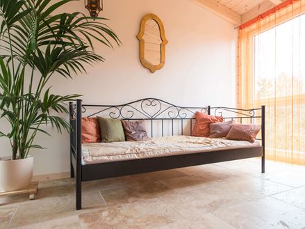 Ložnice s postelí, rostlinou a Rustic travertinem na podlaze