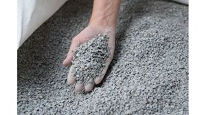 Ruka vybírá štěpky z velkého pytle.