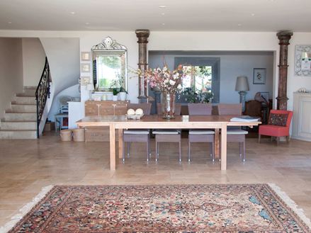 Vstupní prostor hotelu s perským kobercem a dřevěným stolem na travertinových dlaždicích