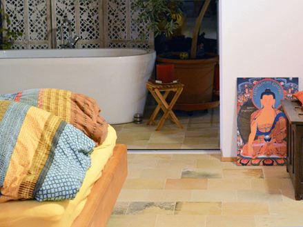 Ložnice s barevnými polštáři a vápencovou podlahou Solnhofen