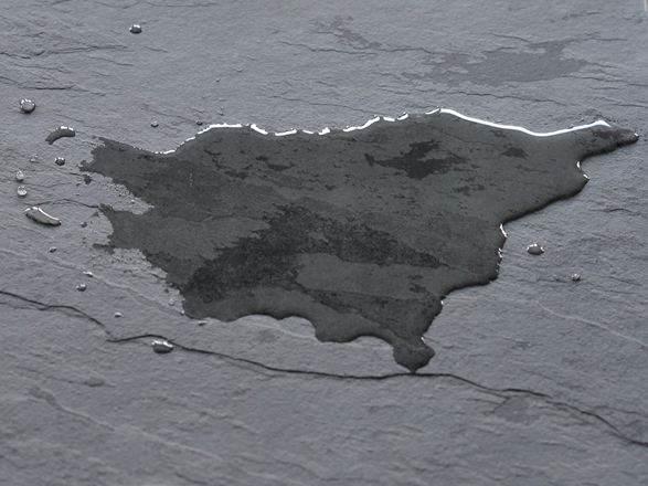 Tmavá břidlicová dlažba s louží vody