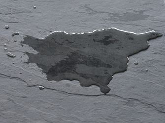 Tmavá břidlicová dlažba s louží vody