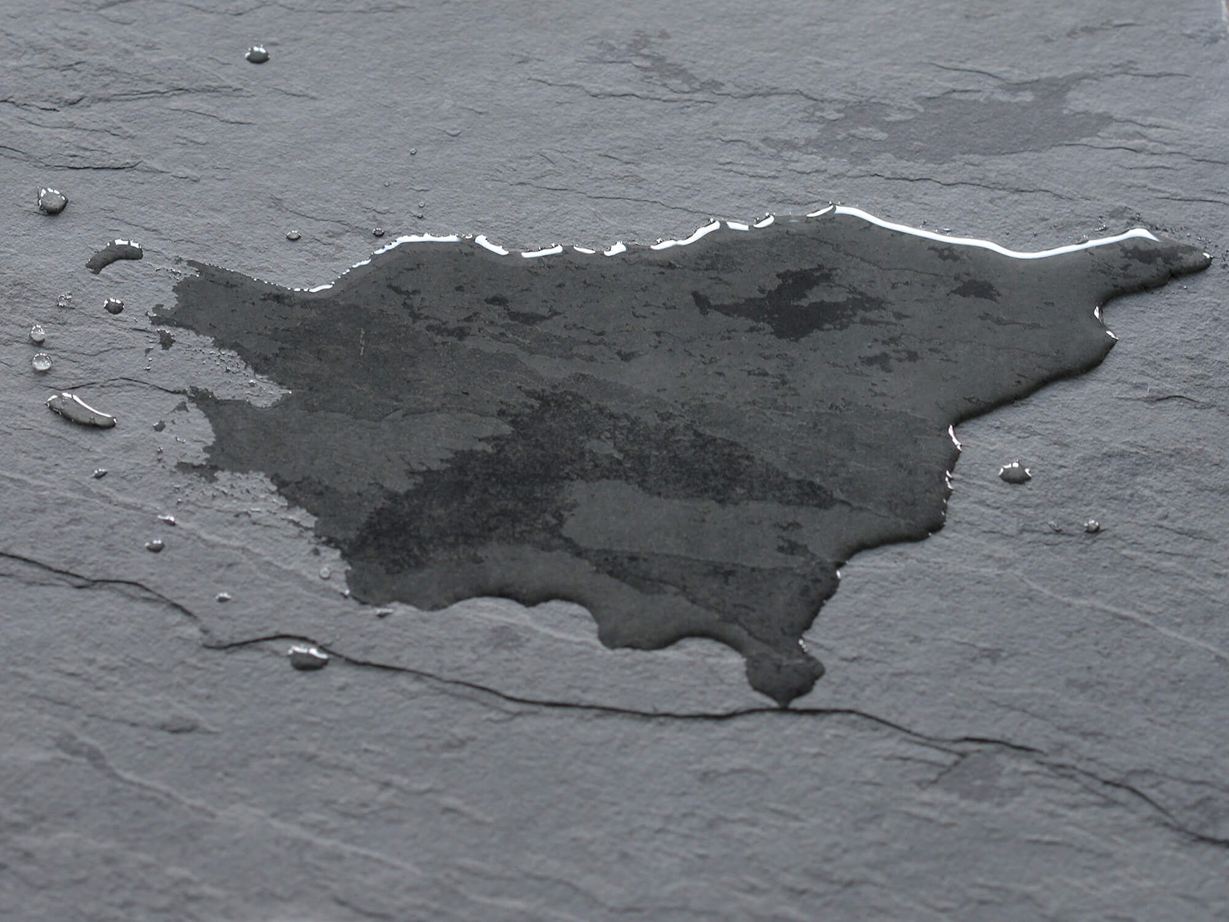 Tmavá břidlicová dlažba s louží vody