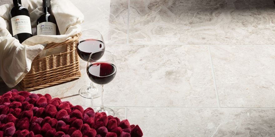 Dvě sklenice na víno stojí vedle naplněného košíku s jahodami na mramorových dlaždicích Silver Shadow.