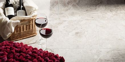 Dvě sklenice na víno stojí vedle naplněného košíku s jahodami na mramorových dlaždicích Silver Shadow.