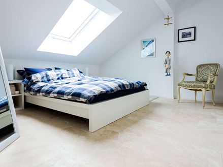 Světlá ložnice pod střechou s dlažbou Medium Line jako podlahou