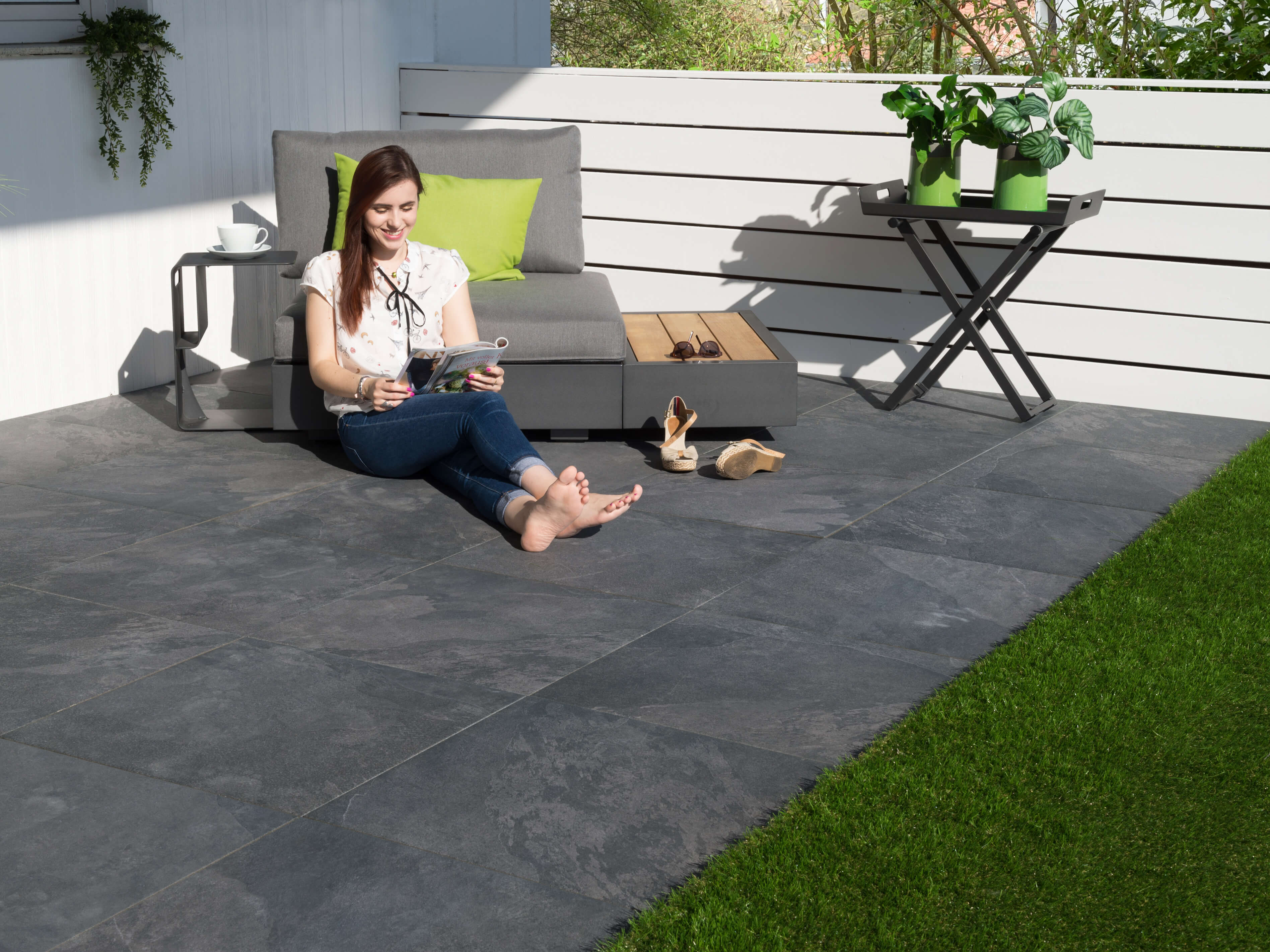 Žena sedící na terasových deskách Alpine Black